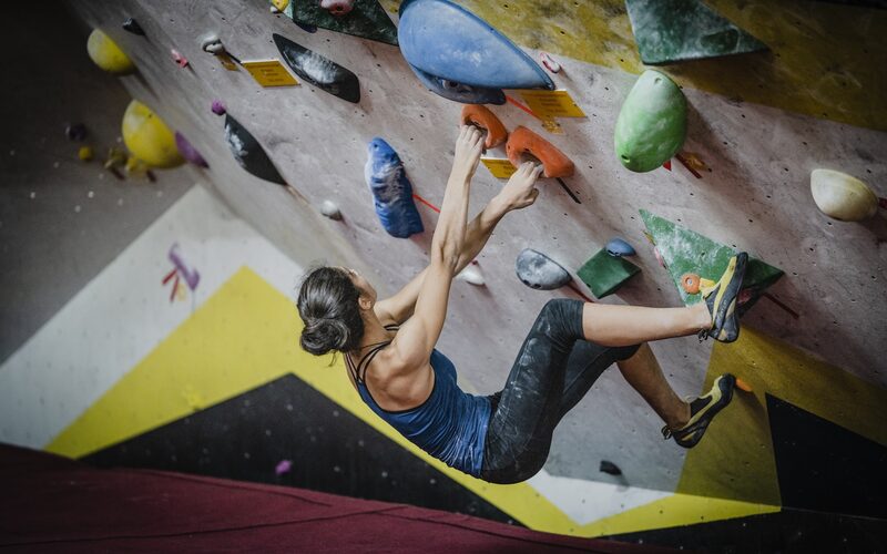 A climber working a problem on an indoor bouldering wall
